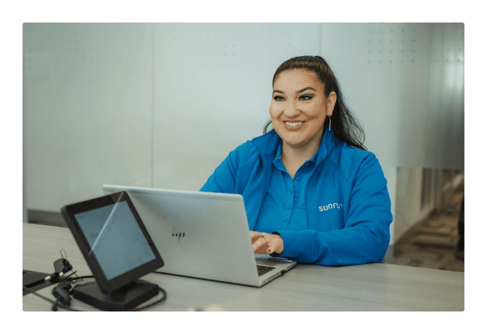 Employee smiling, working on laptop