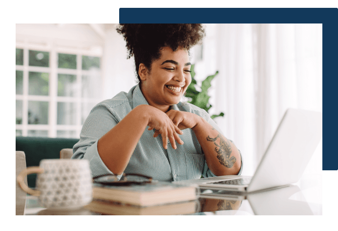 Person smiling while looking at laptop