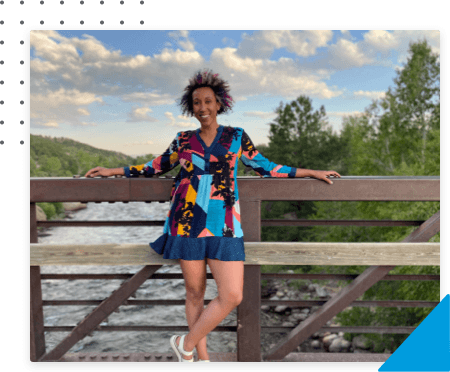 Team Member smiling and presenting to a conference room with her peers