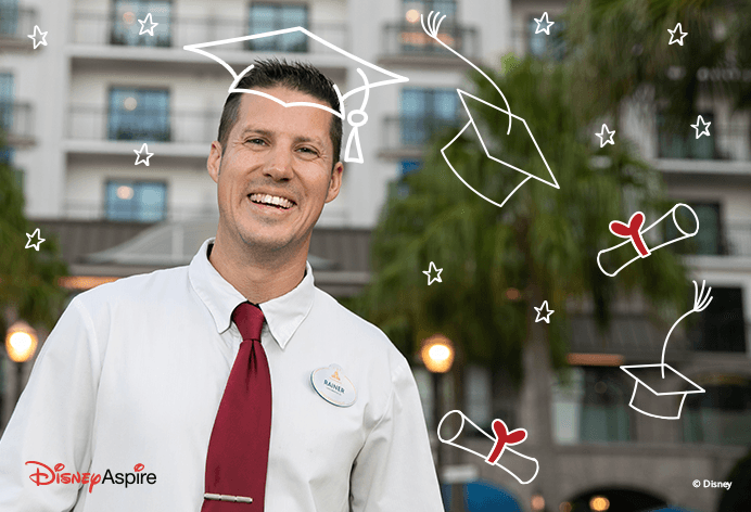 Man smiling in graduation cap in front of Disney castle