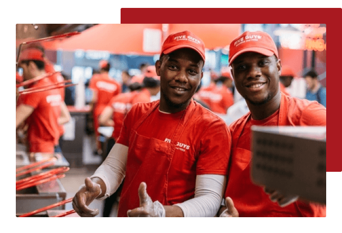 Student giving thumbs up and smiling with other student